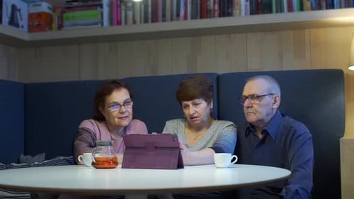 Personas mayores viendo el álbum de fotos en una tableta