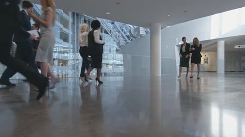 Business People Walking in Modern Workplace Lobby