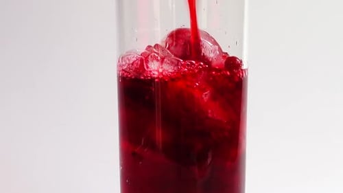 Red Liquid Poured Over Ice in Glass