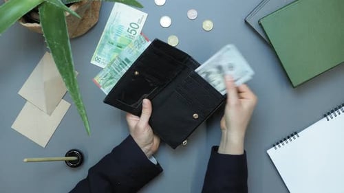 Woman opening wallet, pulling out cash money and counting them