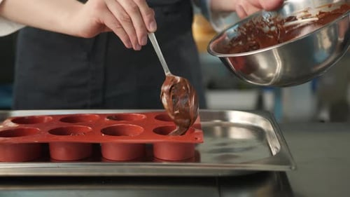 Nahaufnahme von Schokolade, die in eine Auflaufform gelegt wird. Brownie-Zubereitung.