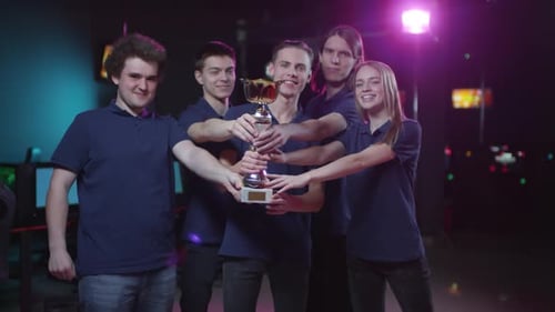 Winning Esports Team Celebrates with Trophy in Office