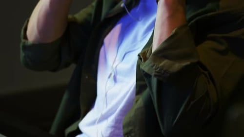 Male audio engineer listening to headphones while mixing sound