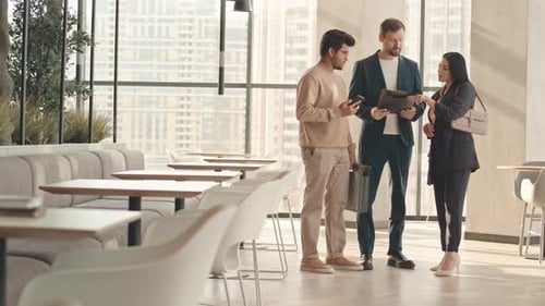 Colleagues Discussing Business Documents in Cafe
