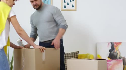 Pareja caucásica guardando cosas para su almacenamiento