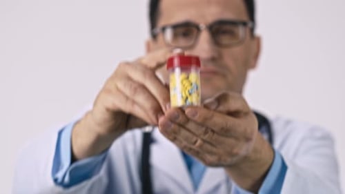 Doctor Presents Bottle of Pills in Close Up