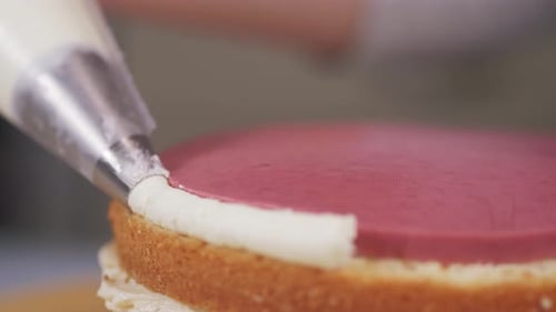 The Pastry Chef Applies the Cream To the Berry Layer Between the Biscuits