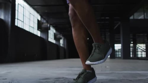 African american man skipping the rope in an empty urban building