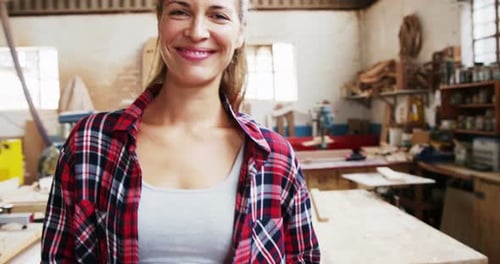 Smiling Woman in Woodworking Shop Holding Mallet