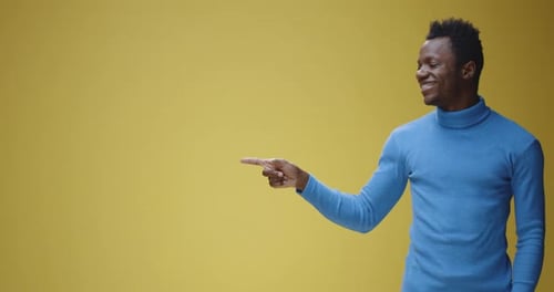 Young Adult Points and Smiles on Yellow Background