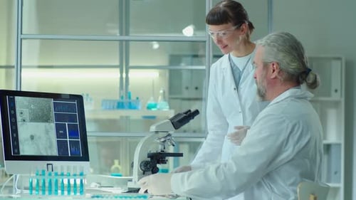 Senior Scientists Working with Young Female Colleague in Lab
