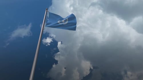 United Nations Flag Waving Against Dynamic Sky
