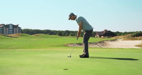 Man Putting Golf Ball on Green Golf Course