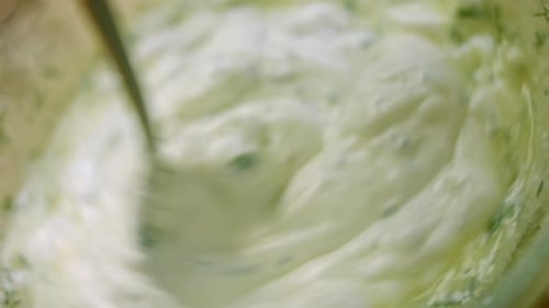 Creamy Herb Sauce Stirred in Glass Bowl