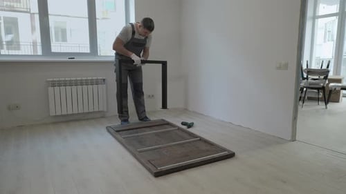 Man Assembling Modern Table in Bright Room