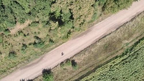 Woman biker riding bicycle on gravel trail