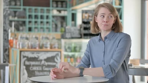 Young Woman Waiting at Cafe Table