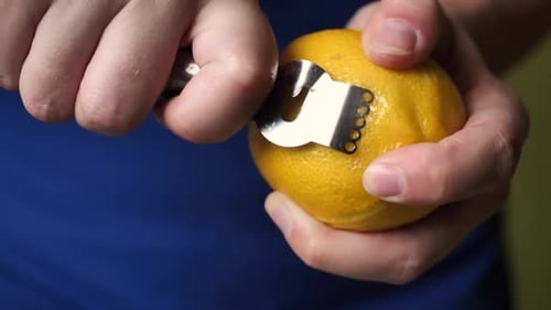 Lemon Being Zested with a Zester Tool