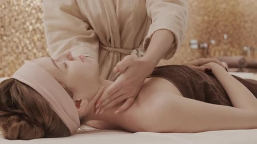 Junge Frau mit Nackenmassage im Spa-Zentrum