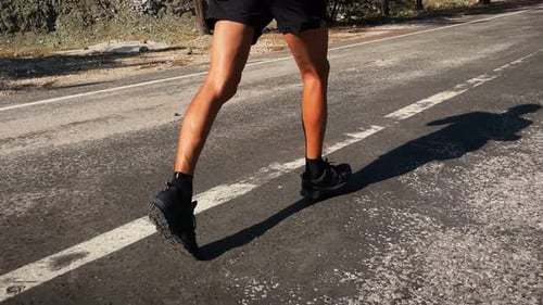Running sport man legs on road, close up.