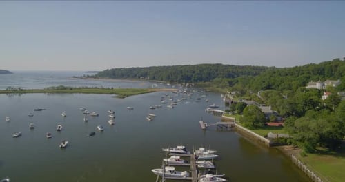 Aerial Pan of a Small Marina and Boats Anchored on Harbor Near a Small Town