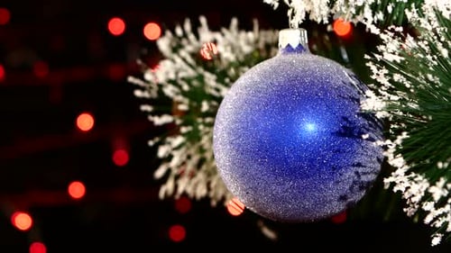 Sparkling Blue Christmas Ornament on Evergreen Branch