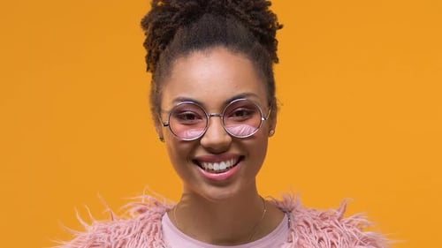 Smiling Young Woman Wearing Glasses and Pink Jacket