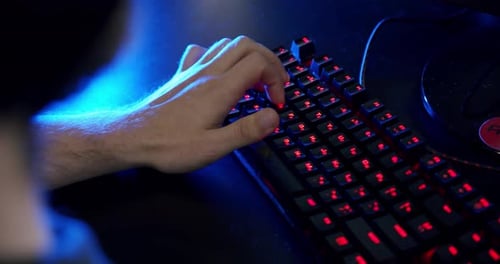 Close-up on the Hands of the Gamer Playing in the Video Game Using Keyboard Background with Cool