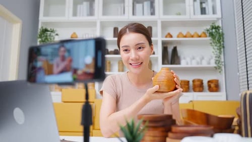Asian beautiful woman sell vase product online live streaming at home.