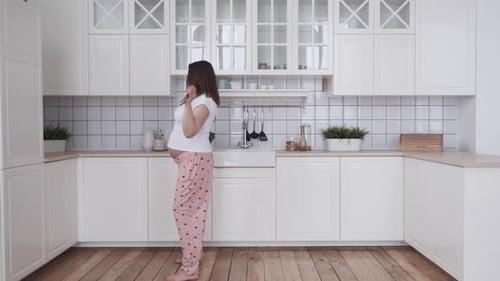 Pregnant Woman Dancing Barefoot in Kitchen