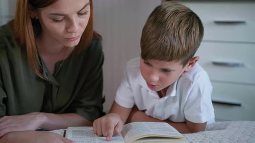 Woman and Child Reading a Book Together at Home