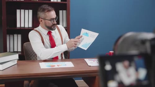 Senior business man video conference showing chart with camera at home office.