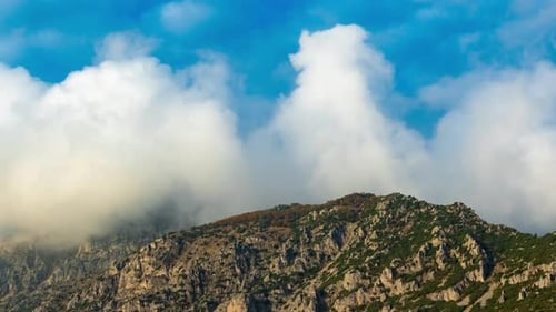 Mountain Peak Covered By Green Plants and Clouds Moving on the Blue Sky in Timelapse