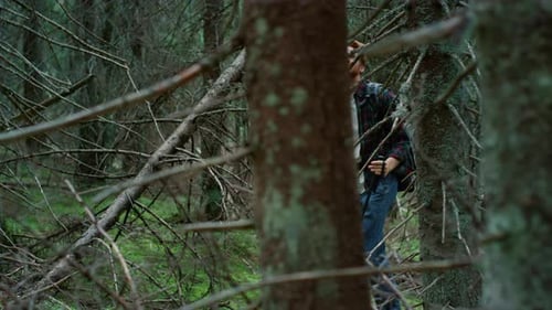 Man with Backpack Trekking in Green Woods