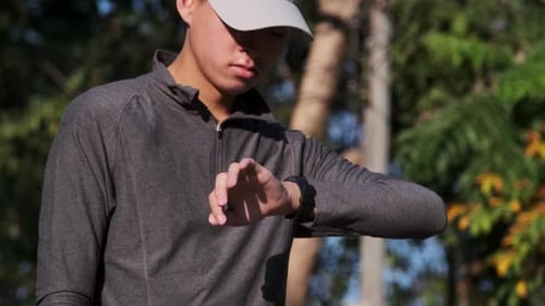 Young Adult Checks Smart Watch After Run
