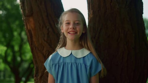 Joyful Little Girl Pose at Tree Trunk