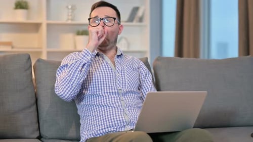 Man Working on Laptop at Home is Tired