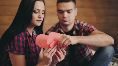 Couple Holding Paper Hearts Talking Indoors