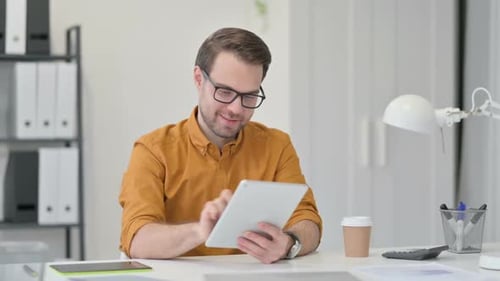 Young Adult Using Tablet in Modern Office