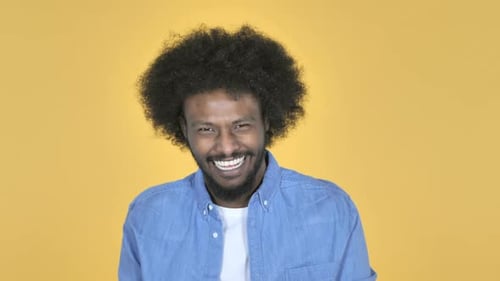 Lachender glücklicher afroamerikanischer Mann auf gelbem Hintergrund