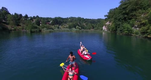Aerial view of friends having fun paddling canoe