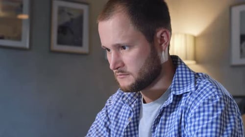 Young Adult Man Works on Laptop Indoors