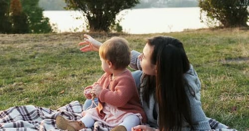 Mother and a Small Daughter, Spends Time Together in a City Park on a Picnic, Young Woman and Little