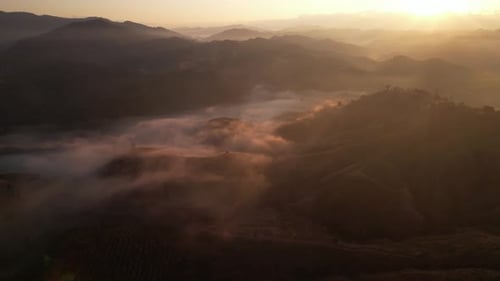 4K aerial view from a drone flying over the valley, fog in the morning.