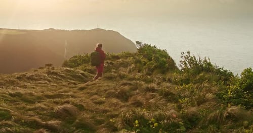Man with a Backpack Hikes Across Windy Hill