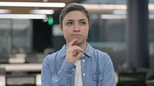 Young Woman Thinking in Modern Office Space