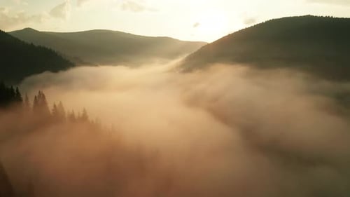 Majestic Mountain Range Shrouded in Fog at Sunrise
