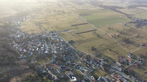 Survoler une forêt et des champs au lever du soleil