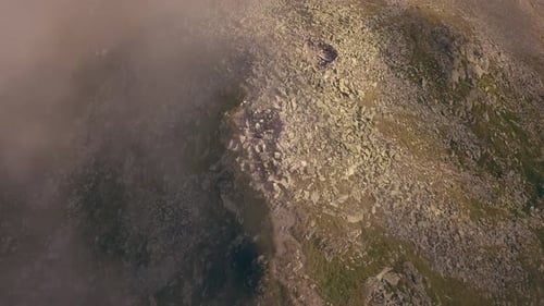 Un Drone aérien se déplace lentement face à un sommet de montagne.