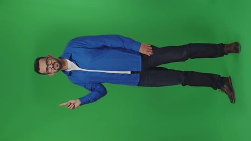 Man Stands on Green Background and Raises His Hand with Index Finger